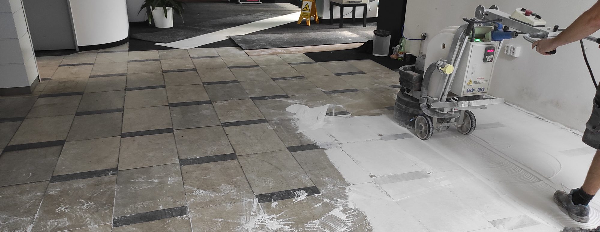 Opotřebovaná kamenná podlaha před renovací, broušení stroje