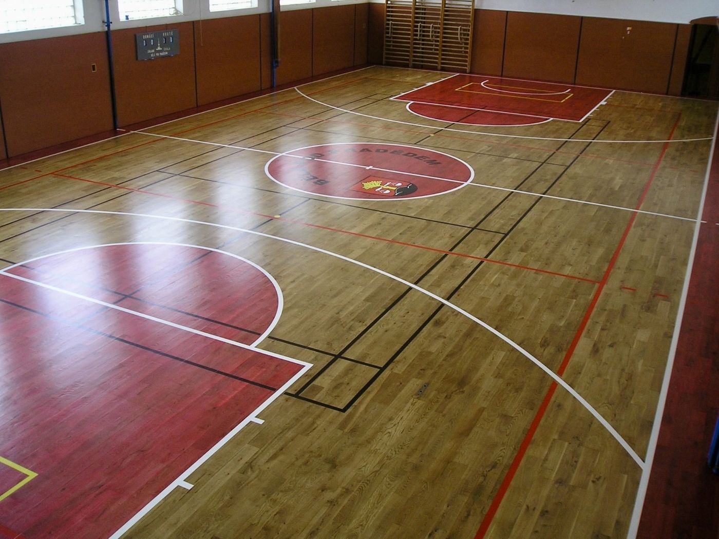Naleštěná palubovka s vylajnováním a klubovým znakem po renovaci