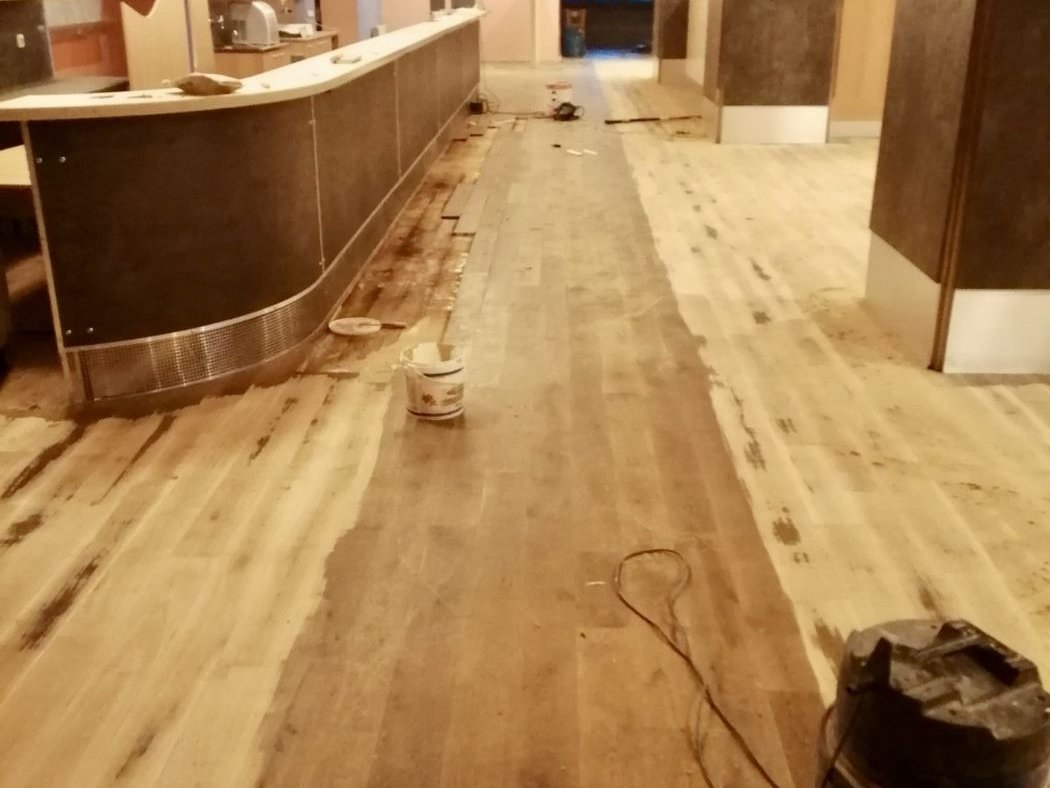 Opotřebovaná dřevěná podlaha baru před renovací